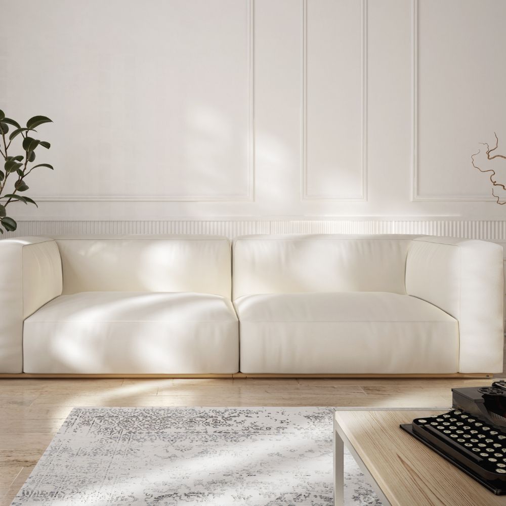 Bright minimalist lounge with white painted walls, natural light, and modern sofa.